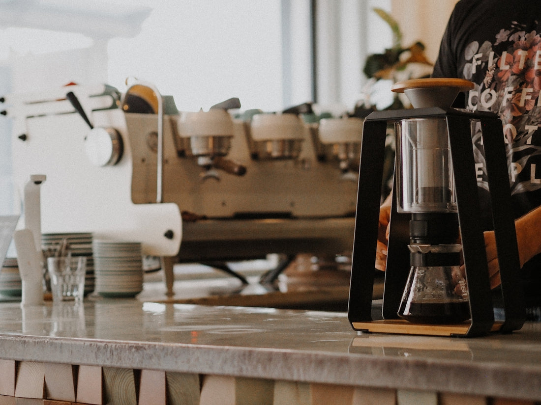 white and silver coffee maker on brown wooden table