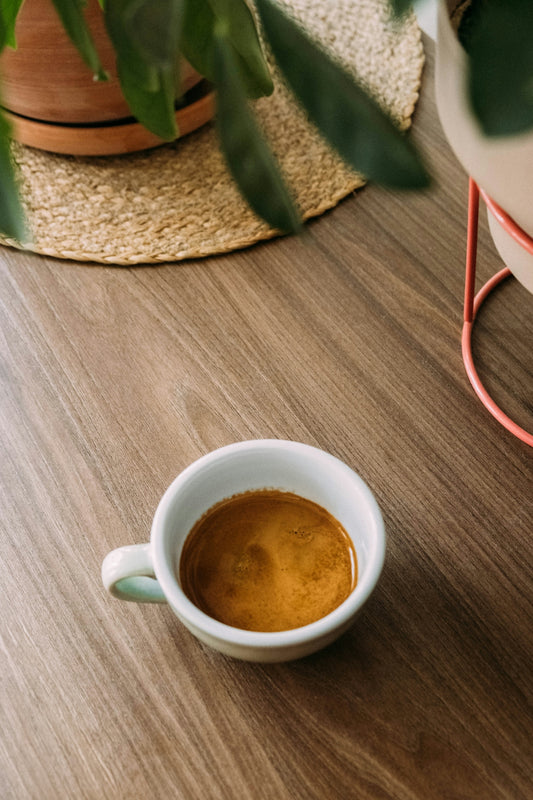 a cup of coffee sitting on top of a wooden table
