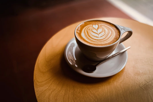 A cup of coffee with latte art on a saucer.