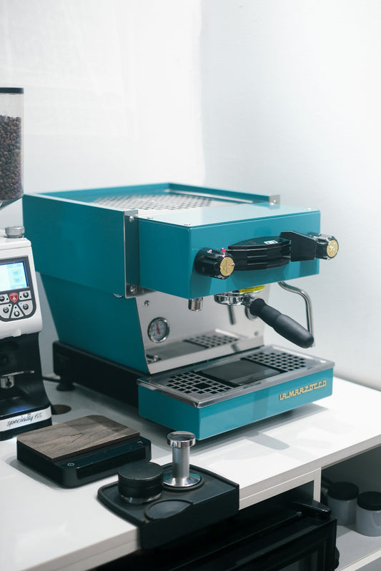 Teal espresso machine with coffee grinder and accessories