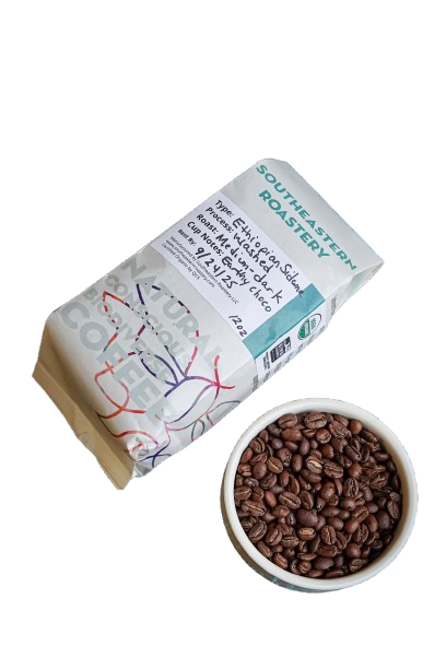 Benevolent Bean Grow To Market 12oz organic Ethiopian coffee bag with colorful label and coffee beans in the background.