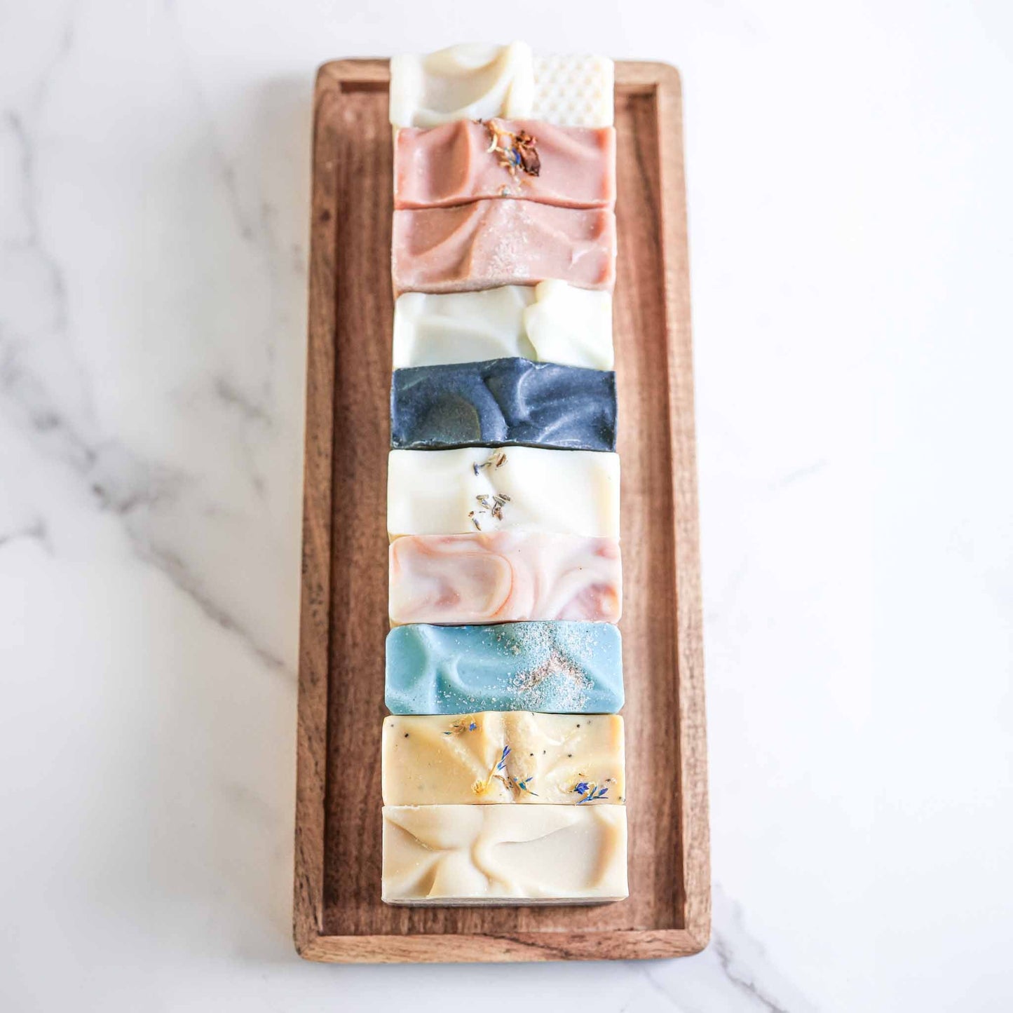 Set of four farmhouse artisan goat milk and tallow soaps by Pretty Farm Girl, showcasing rustic packaging and natural ingredients.