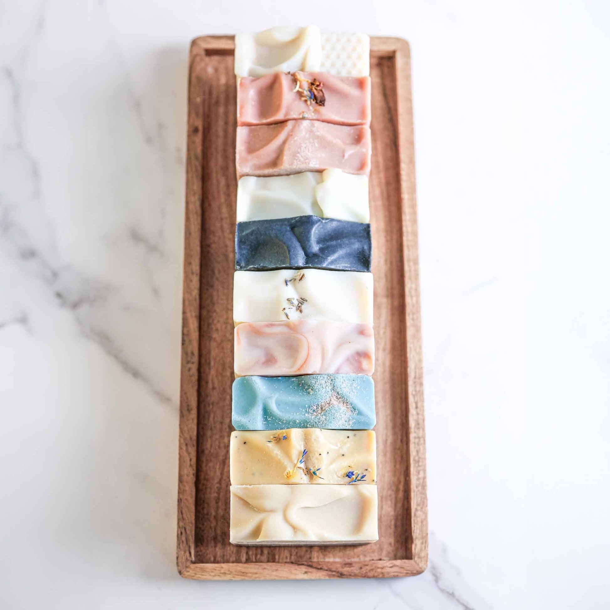 Set of four farmhouse artisan goat milk and tallow soaps by Pretty Farm Girl, showcasing rustic packaging and natural ingredients.