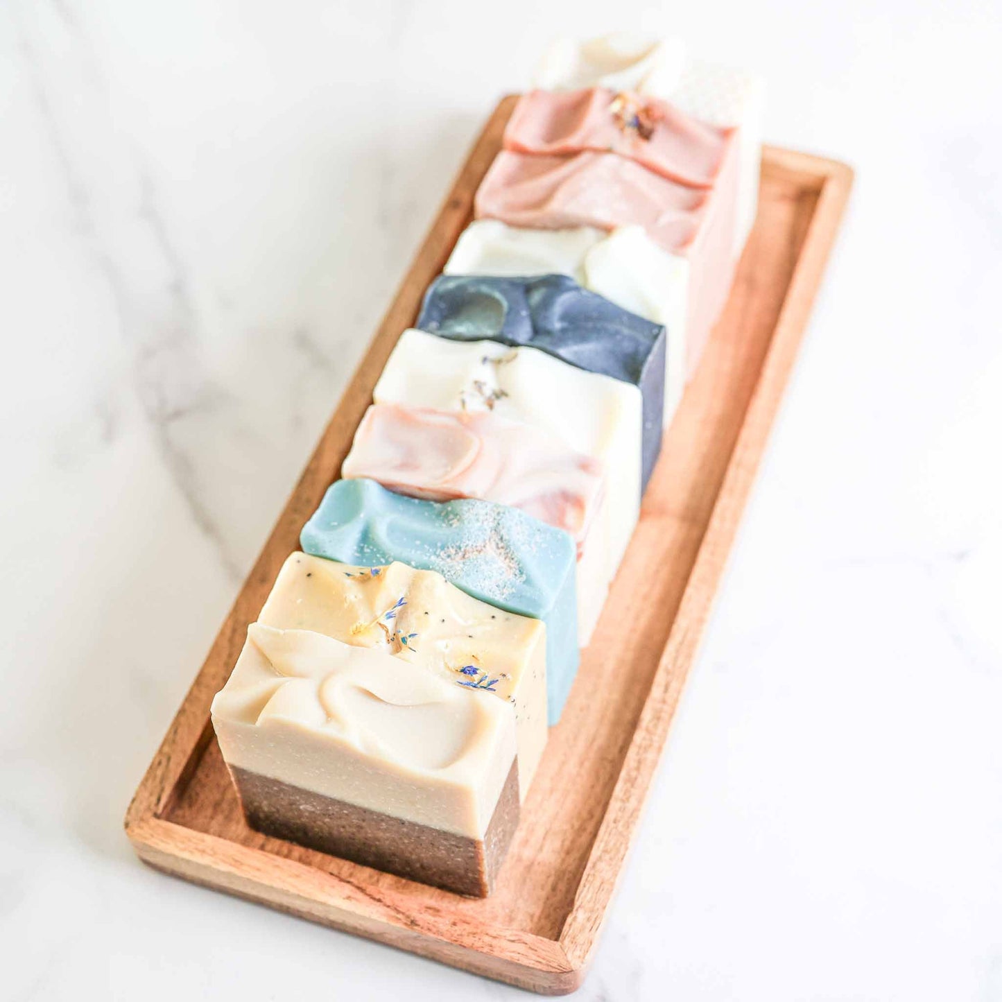 Farmhouse artisan goat milk and tallow soap collection by Pretty Farm Girl, featuring natural handmade soap bars in a rustic setting.
