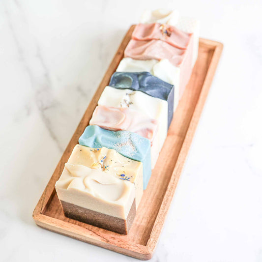 Farmhouse artisan goat milk and tallow soap collection by Pretty Farm Girl, featuring natural handmade soap bars in a rustic setting.