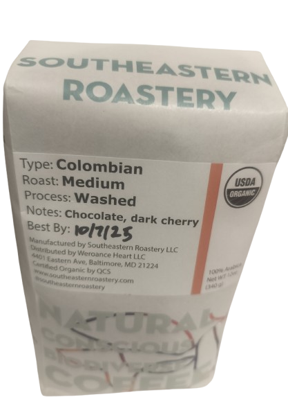 Benevolent Bean MAEOE 120z organic Colombian coffee medium roast in a bag with a label and coffee beans nearby.