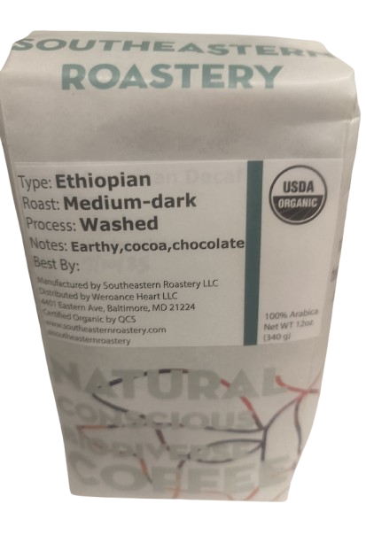 Benevolent Bean 12oz organic Ethiopian dark roast coffee bag with label and branding, ready for brewing.