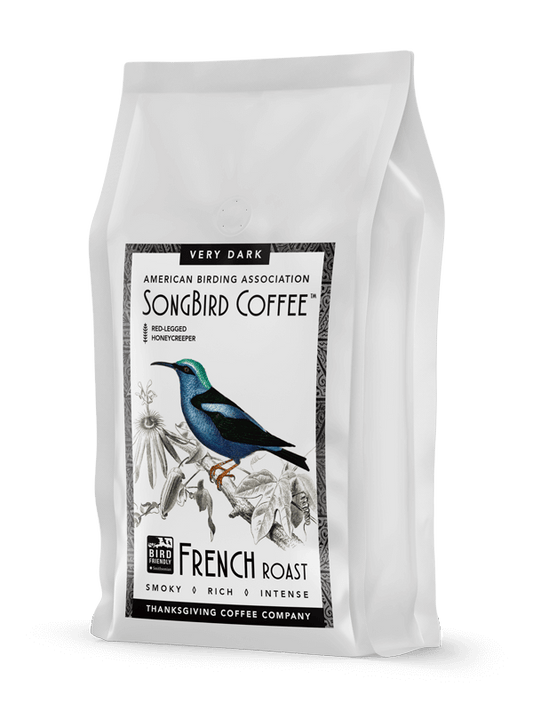 Dark roast coffee beans from SongBird French blend by Thanksgiving Coffee Company, shown in a close-up image.