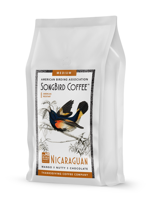 Medium roast SongBird Nicaraguan coffee bag by Thanksgiving Coffee Company, featuring vibrant packaging and fresh coffee beans.