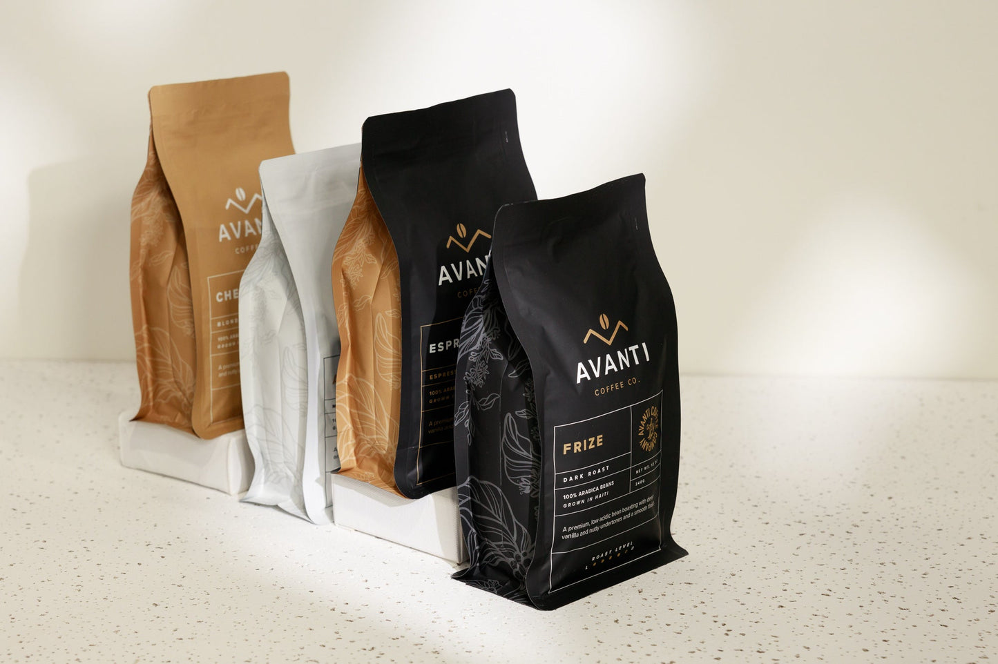 Assorted coffee beans and accessories in the Ultimate Coffee Lover Gift Set by Avanti Coffee Company on a wooden surface.