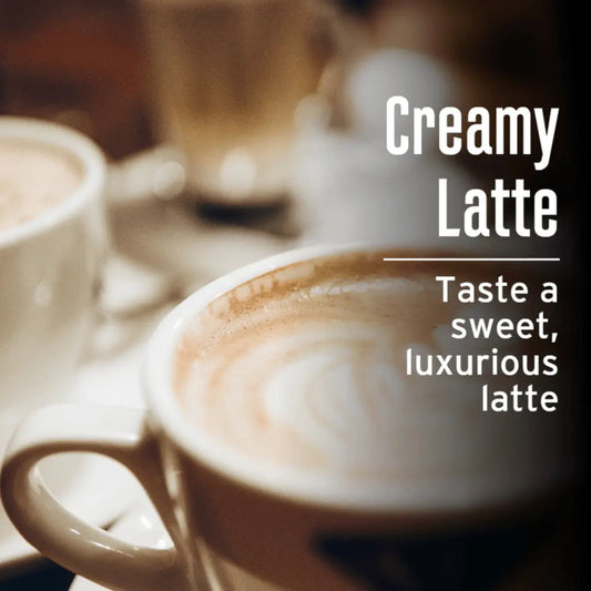 Creamy Latte flavored coffee by JavaMania in a ceramic mug, topped with foam and a sprinkle of cocoa powder.