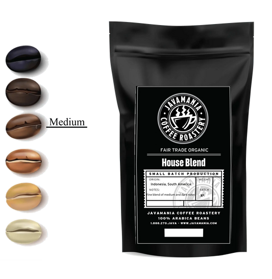 Cup of JavaMania Fair Trade Organic House Blend coffee in a white mug on a wooden table, showcasing a rich, dark coffee with crema.