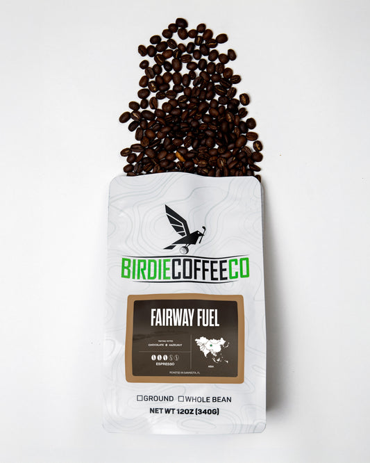 Medium roast Fairway Fuel coffee by Birdie Coffee Company in a sealed bag with a coffee scoop and grounds on a wooden surface.