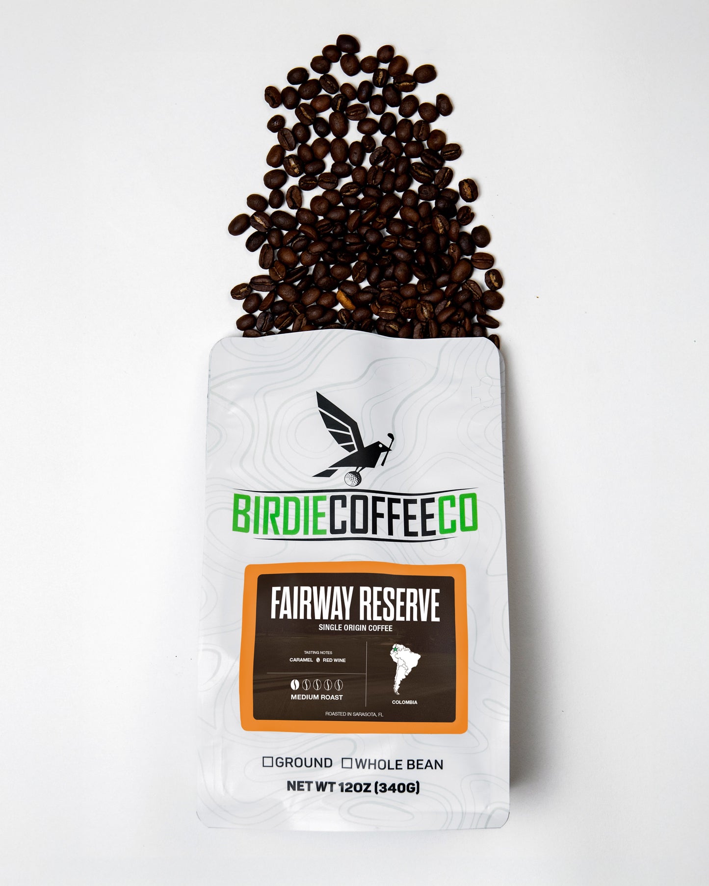 Birdie Coffee Company Fairway Reserve Colombia Coffee bag with coffee beans and brewing setup on a wooden table.