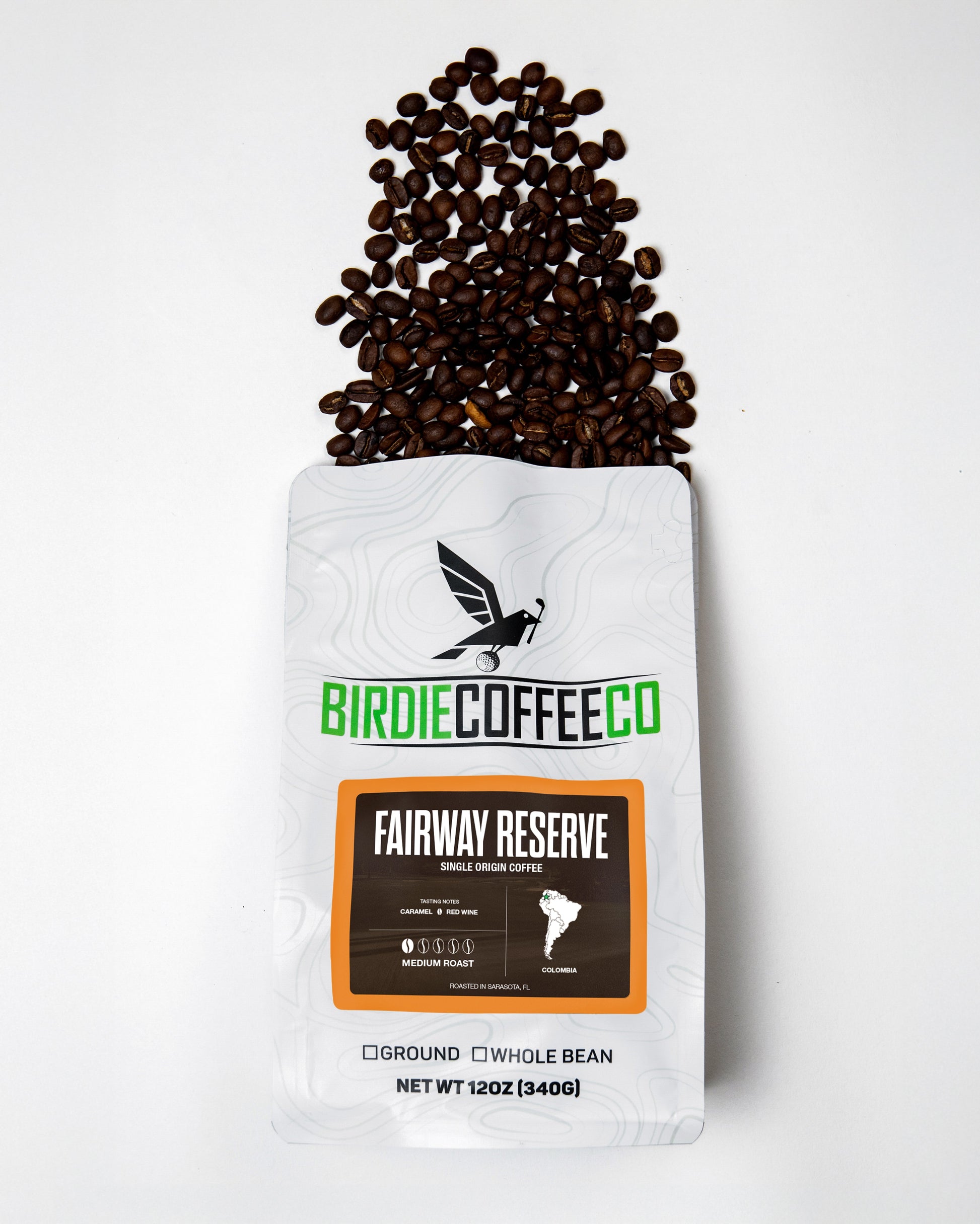 Birdie Coffee Company Fairway Reserve Colombia Coffee bag with coffee beans and brewing setup on a wooden table.