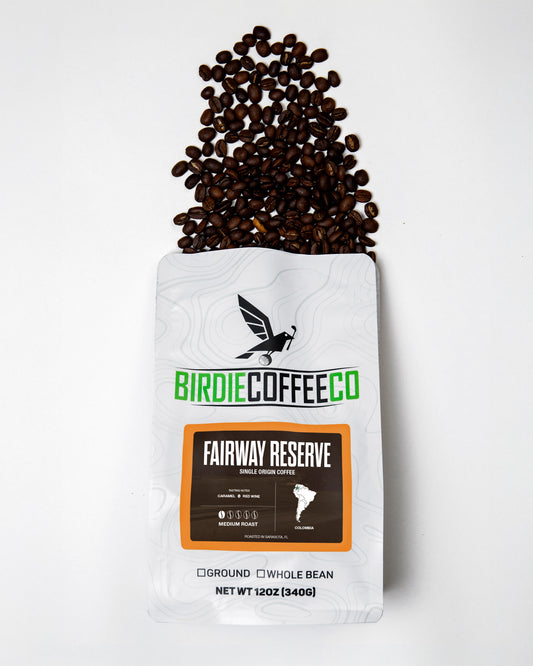 Birdie Coffee Company Fairway Reserve Colombia Coffee bag with coffee beans and brewing setup on a wooden table.
