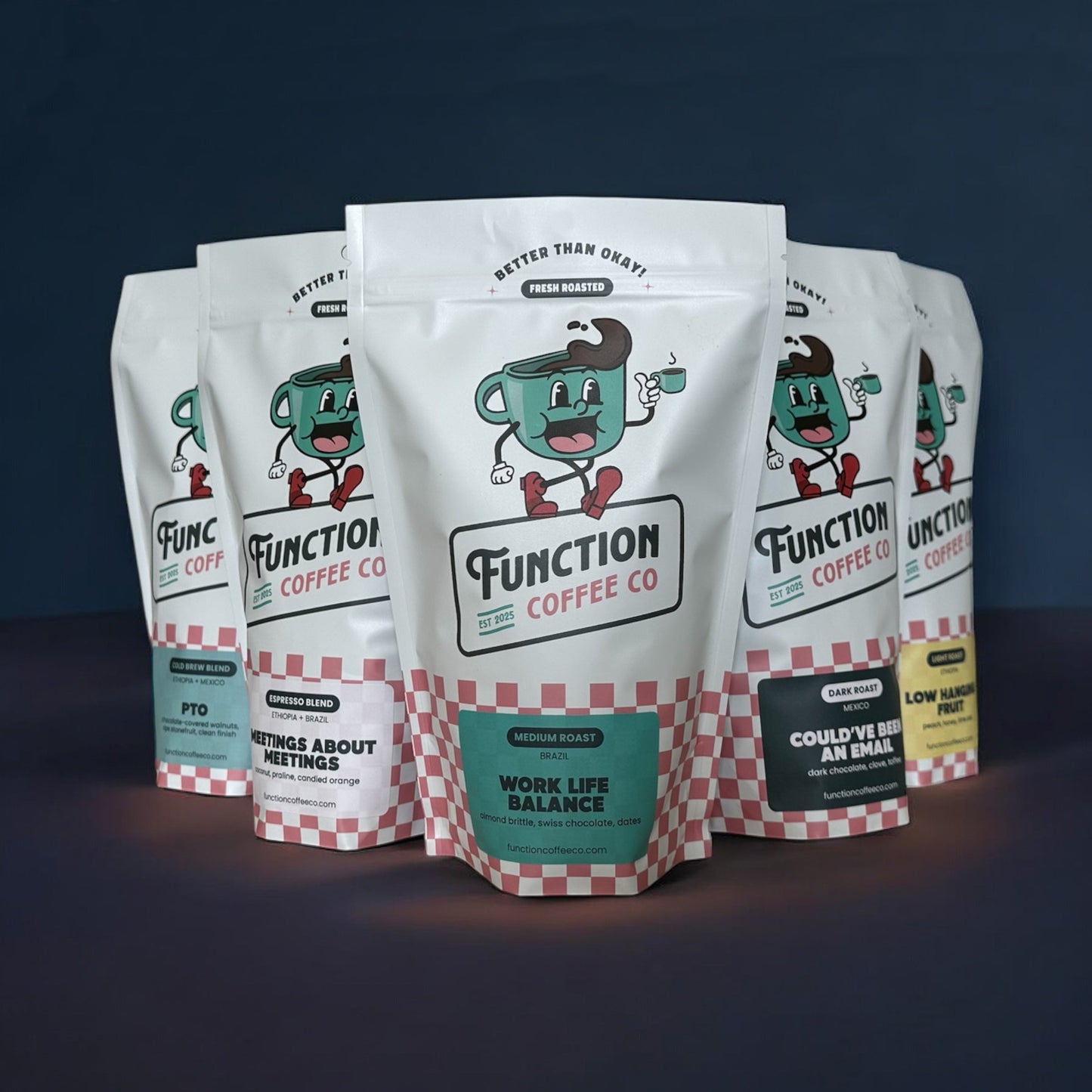 Assortment of Function Coffee Co's The Founder's Box with whole bean and ground coffee in colorful packaging on a wooden table.