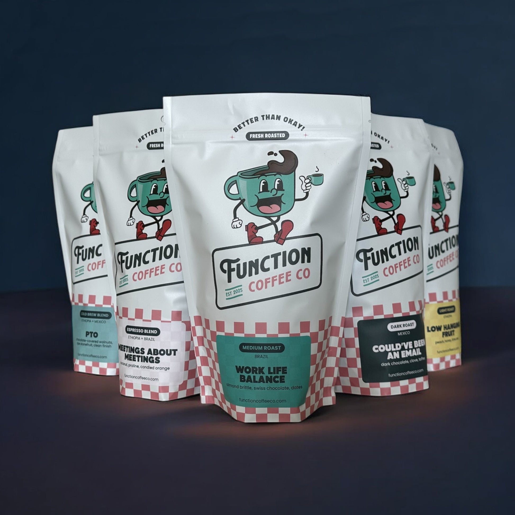 Assortment of Function Coffee Co's The Founder's Box with whole bean and ground coffee in colorful packaging on a wooden table.