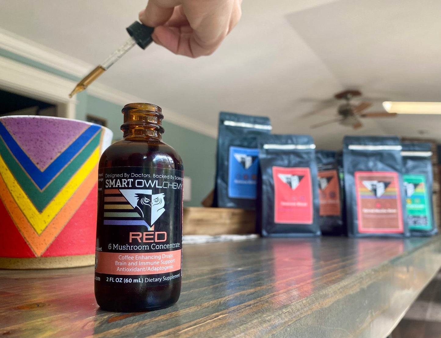 Red Drops Smart Owlchemy mushroom supplement drop in a small 2oz bottle, featuring a bright red liquid and a dropper cap.